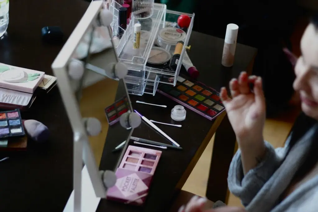 A makeup setup with various cosmetics and mirror reflection captured indoors.