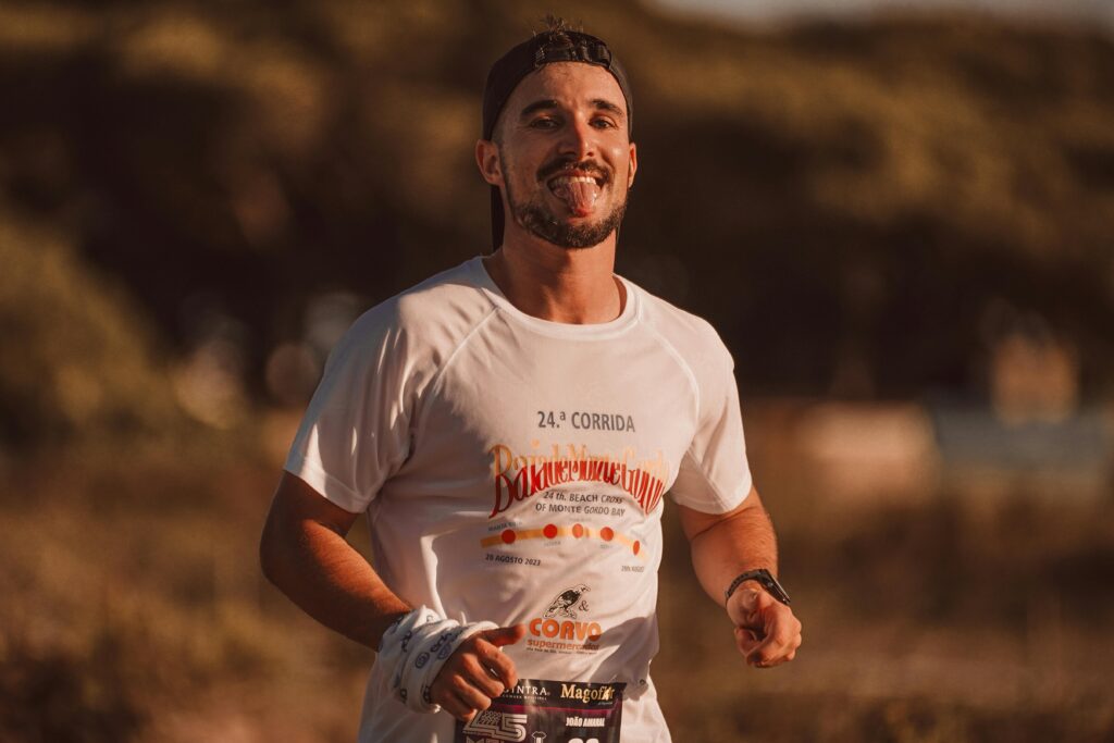 Smiling male runner enjoying a race on a sunny day, expressing joy and energy.