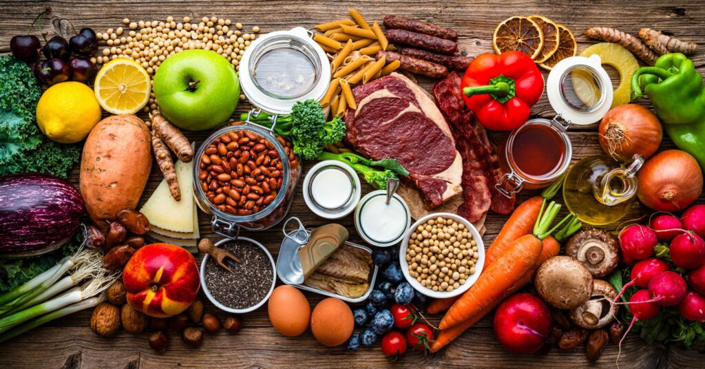 Group of food for healthy and well balanced diet, colorful fruits, vegetables, legumes, meat, canned food and dairy products. Organic source of vitamins, minerals and proteins.