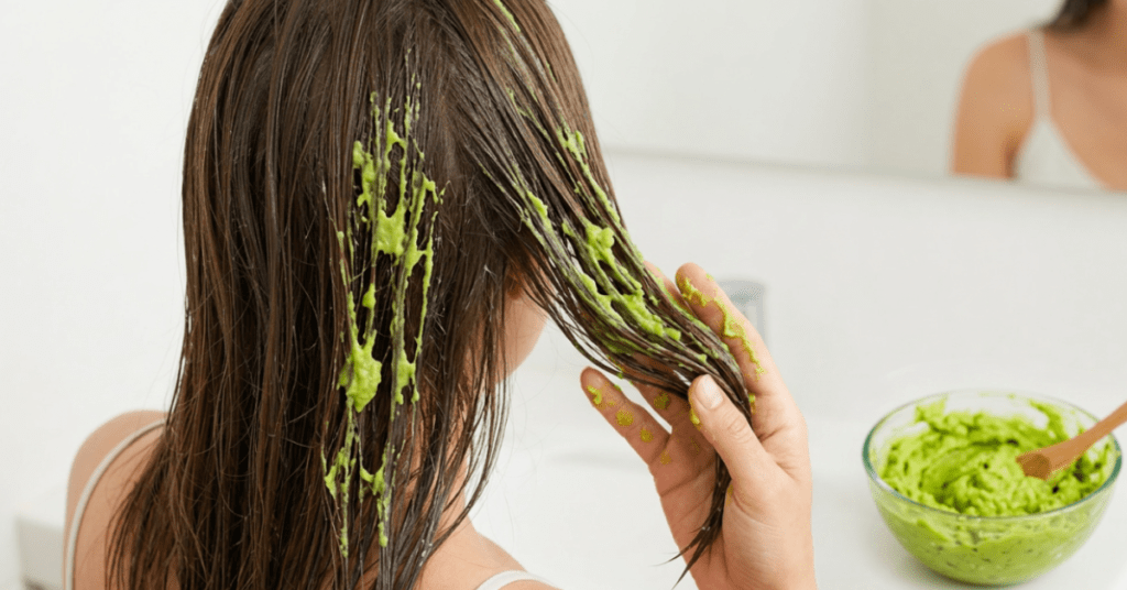 The first step of a nourishing hair care routine, emphasizing the natural, healthy approach to hair treatment with the rich, green avocado-based mask against her damp locks. The first step of a nourishing hair care routine, emphasizing the natural, healthy approach to hair treatment with the rich, green avocado-based mask against her damp locks.